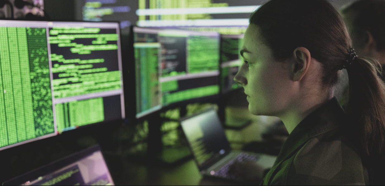 Female worker sitting in front of screens